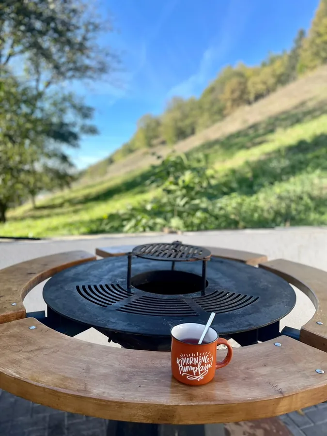 Autumn coffee at the round grill, with a hillside view
